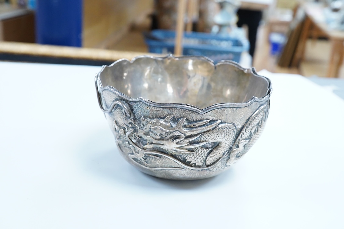 An early 20th century Japanese planished white metal double walled sugar bowl, decorated with the continuous scene of a dragon, signed to the base, diameter 12.1cm, 5.9oz(a.f.).